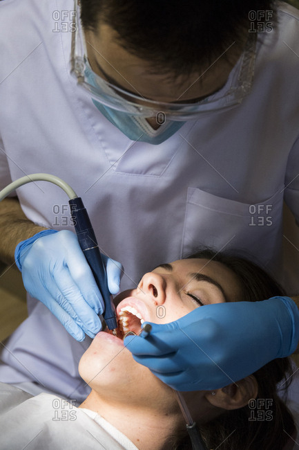 Close-up of dentist giving medical treatment to patient at clinic