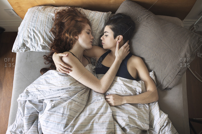 High Angle View Of Romantic Lesbian Couple Looking At Each Other On Bed
