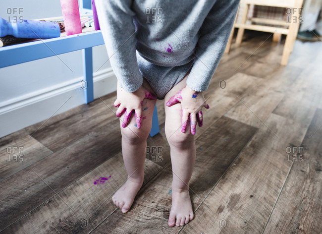 Low section of girl standing with hands on knees