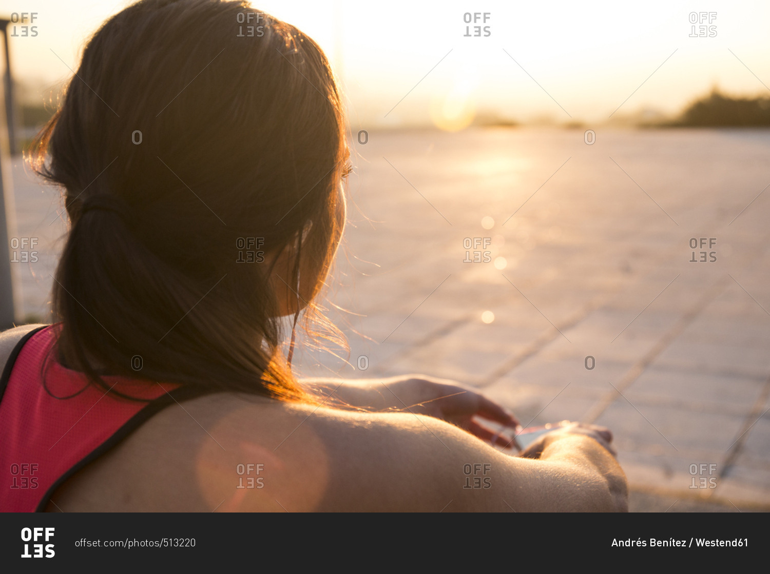 Resting female athlete looking at sunset