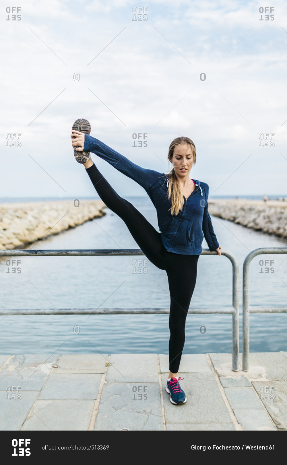 Young woman doing yoga poses at the the beach