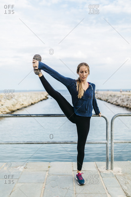 Young woman doing yoga poses at the the beach