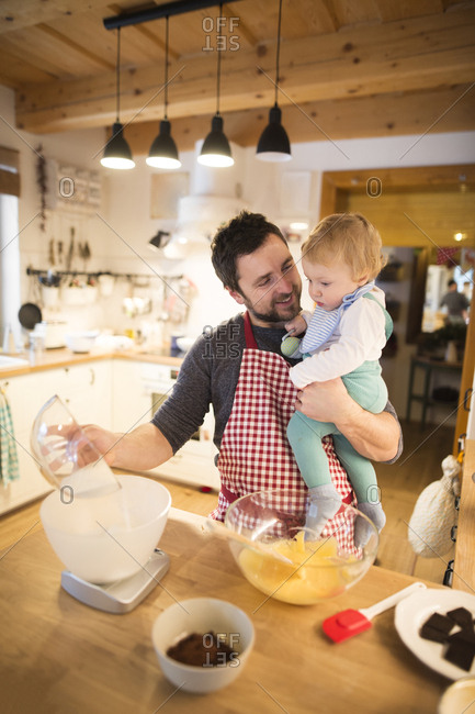 Father and baby boy in kitchen baking a cake