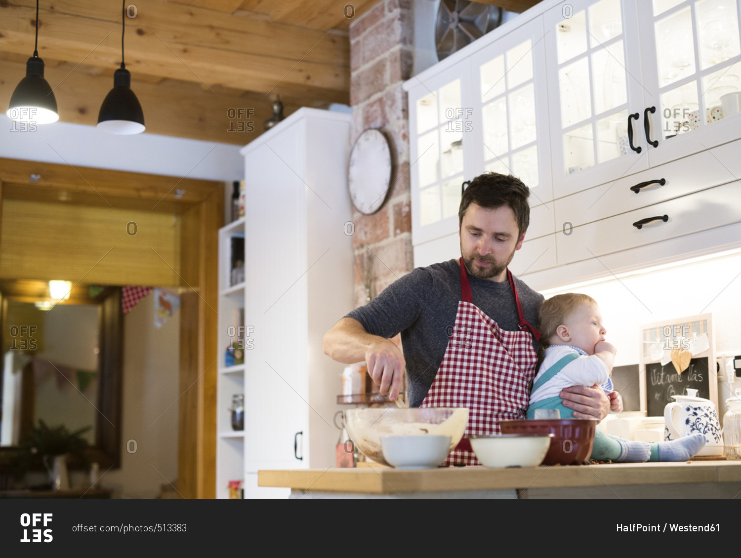 Father and baby boy in kitchen baking a cake