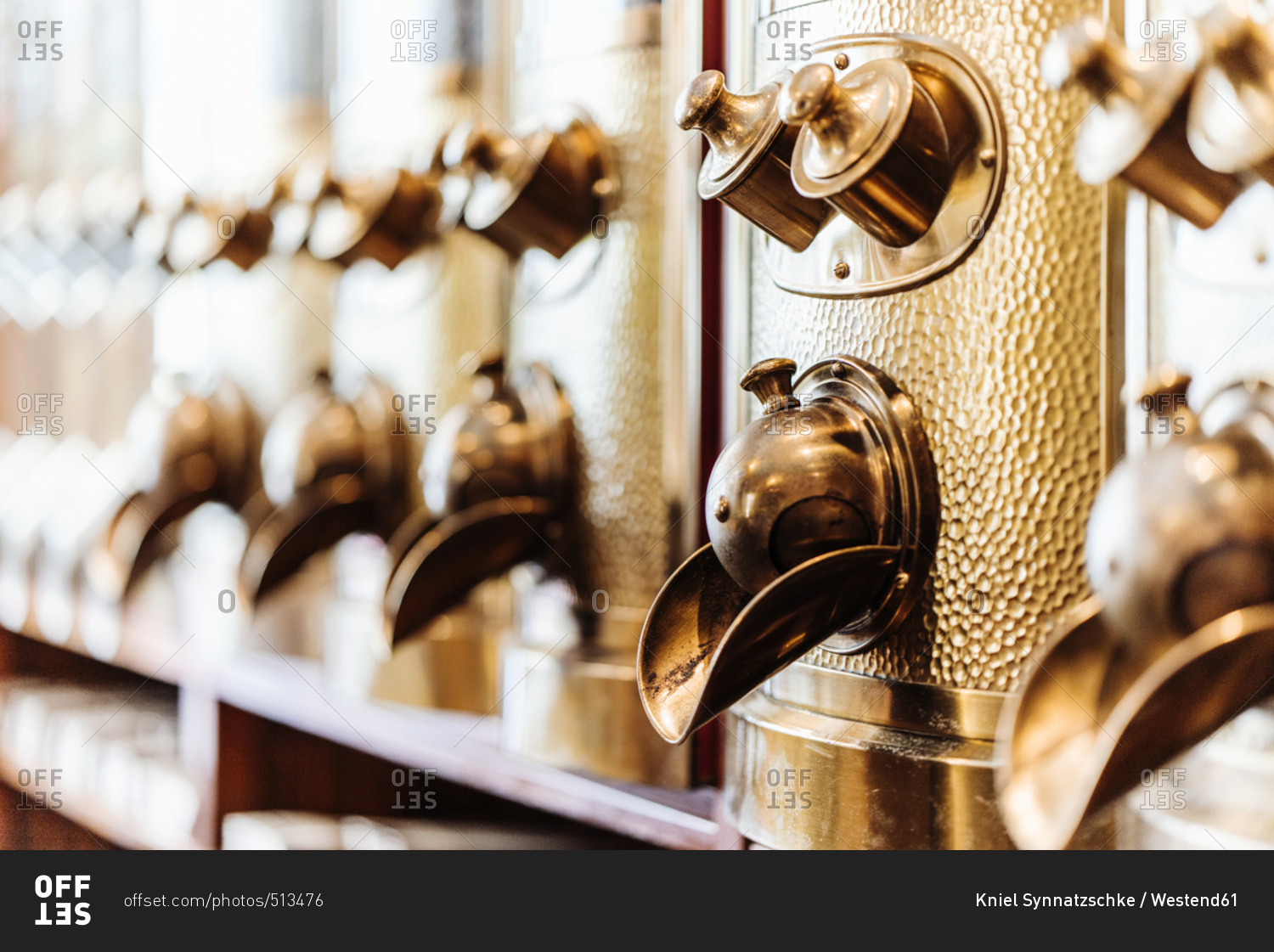 Row of brass coffee dispensers