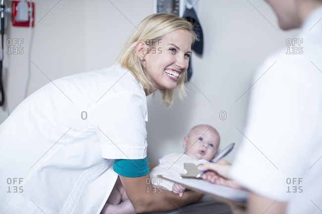 Female pedeatrician holding baby at examination