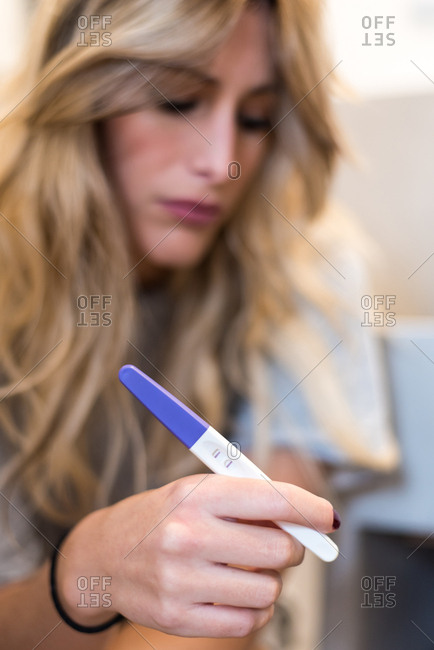 Worried sad woman Looking at a Pregnancy Test after results