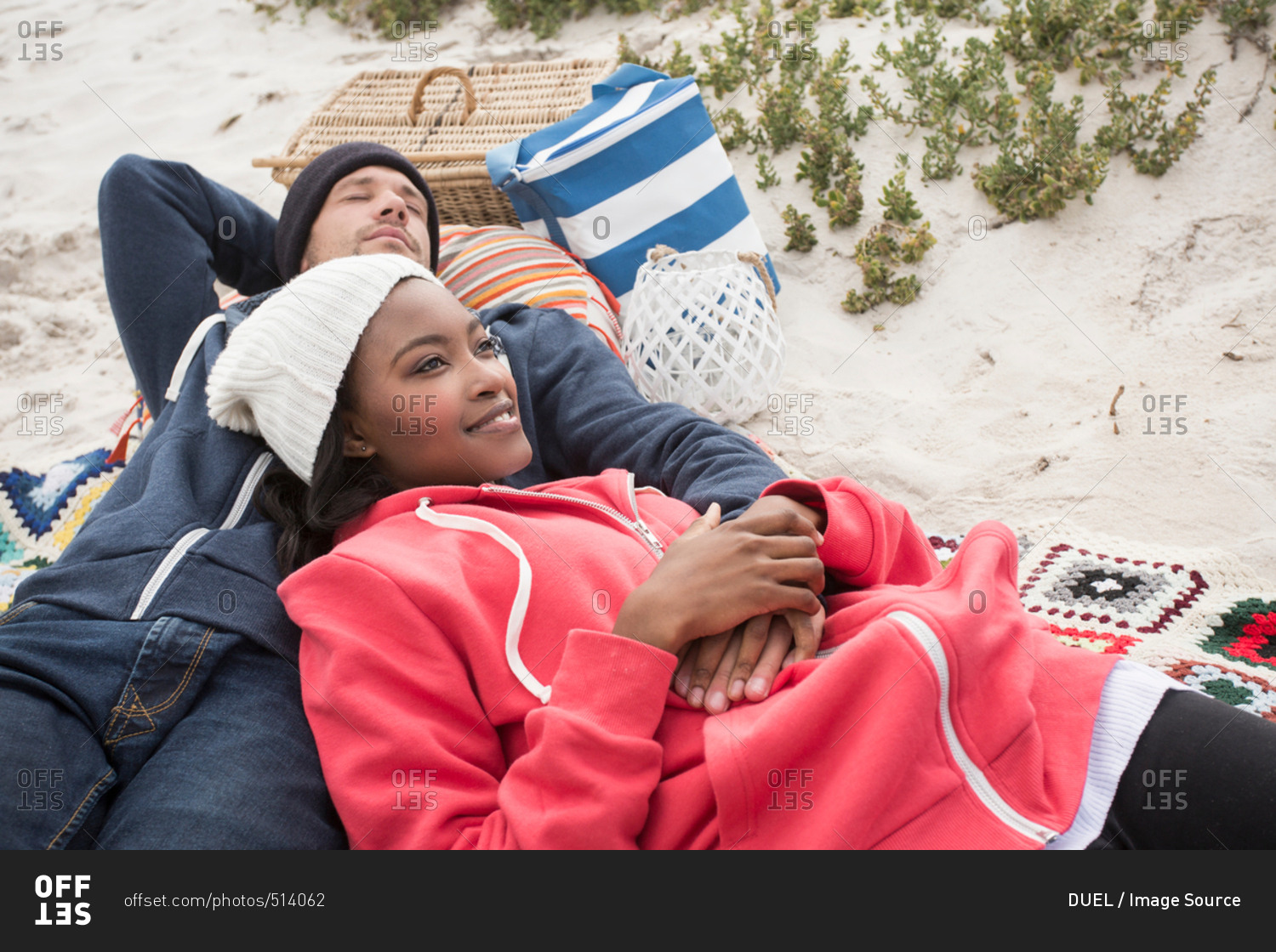 Young couple reclining on picnic blanket at beach, Western Cape, South Africa