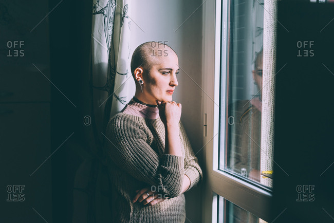 Portrait of a young woman with shaved head, wearing bra stock photo - OFFSET