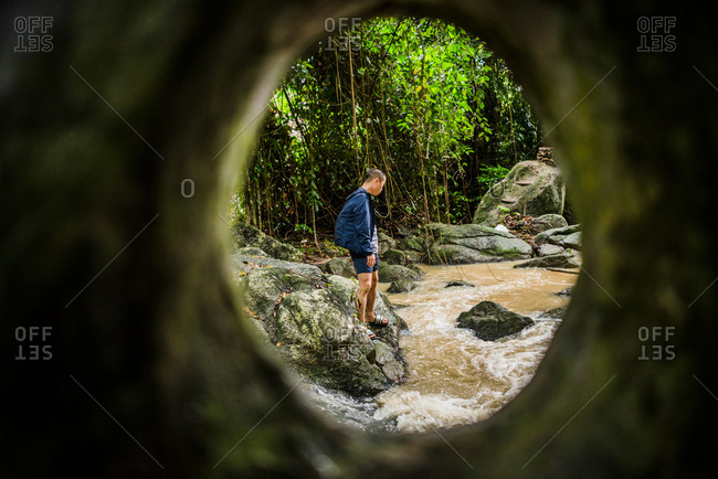 Young man watching flowing stream, Secret Buddha Garden, Koh Samui, Thailand