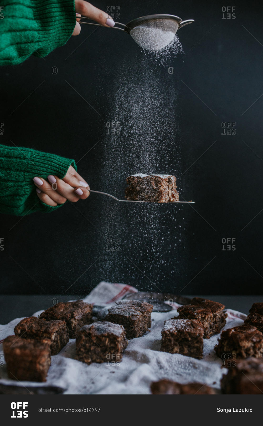 Person sifting powdered sugar on homemade vegan brownies