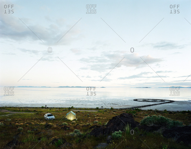 Campsite near a remote shore at dusk