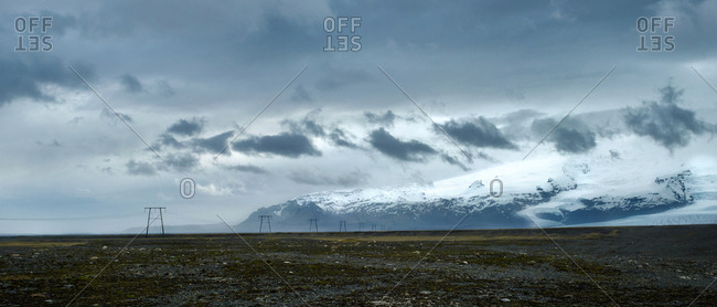 Power lines run across the vast open landscape of rural Iceland
