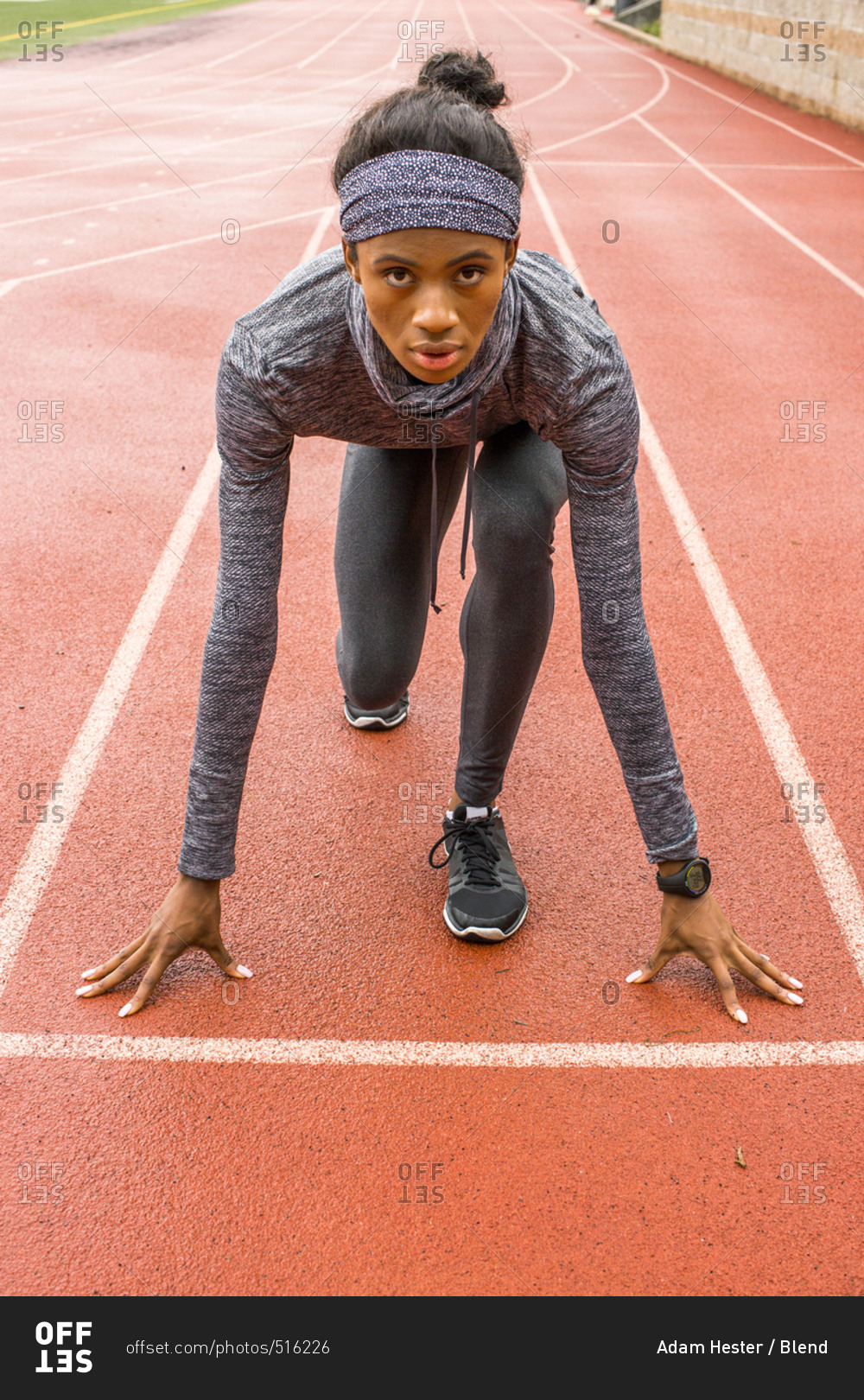 Black woman waiting at starting line on track