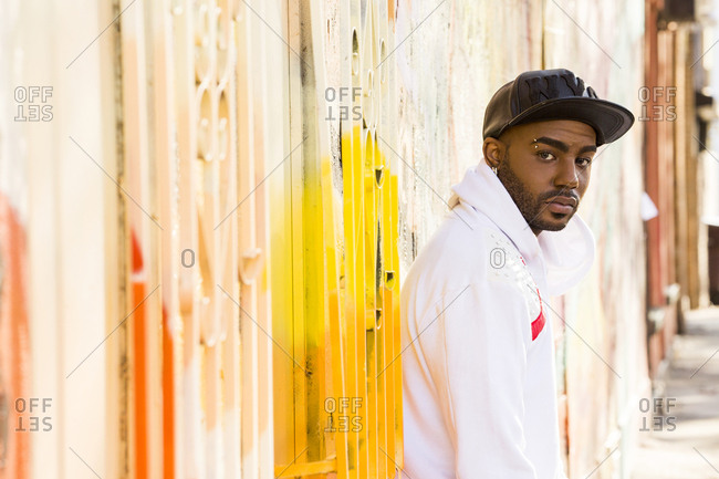 Serious Black man standing near gate