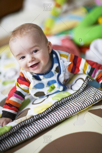 Baby boy on belly playing on quilt in play room