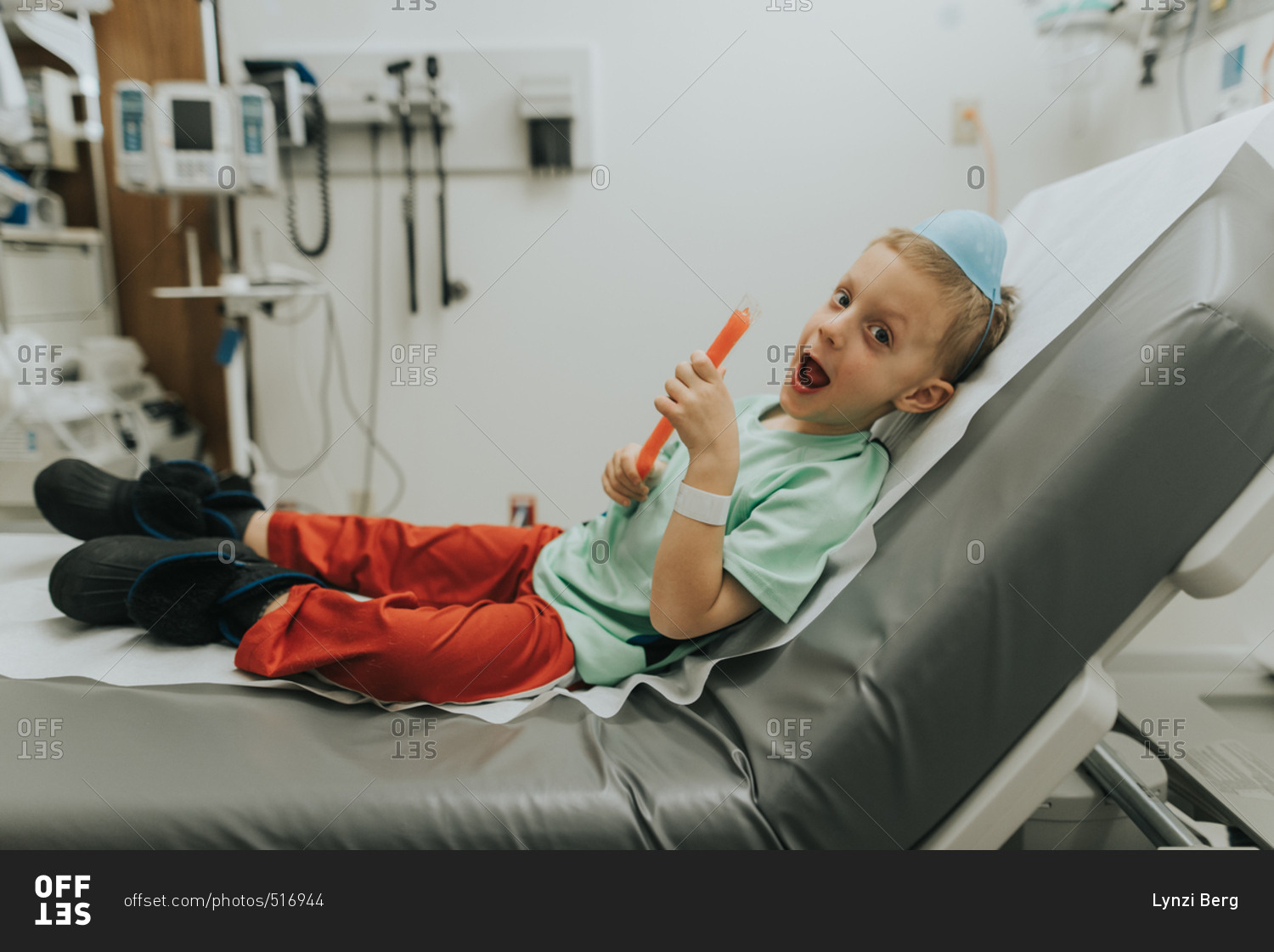 Boy in hospital bed eating popsicle stock photo OFFSET