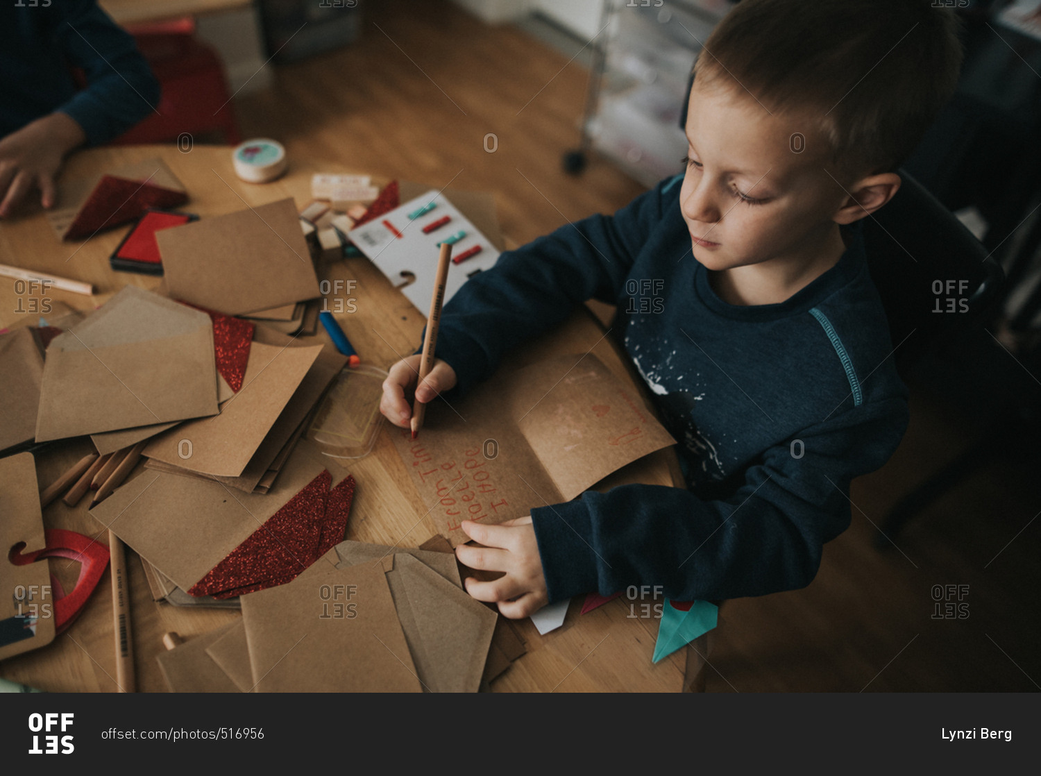 Young boy writing note in a Valentine's day card