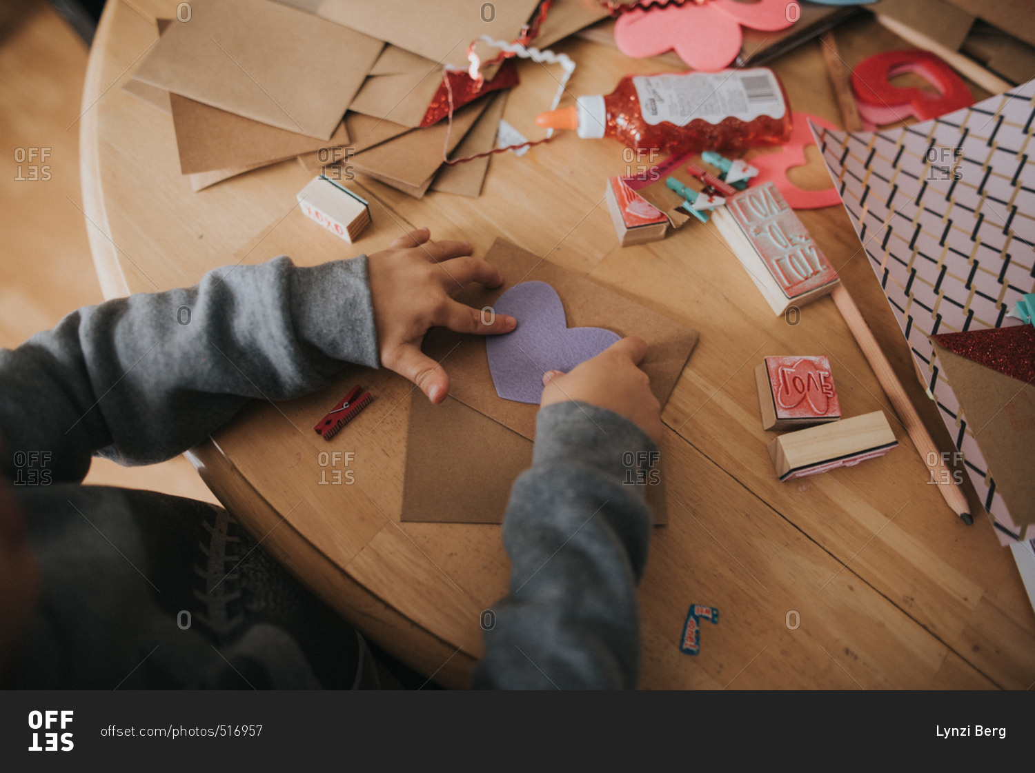 Boy putting hearts onto a Valentine's day card