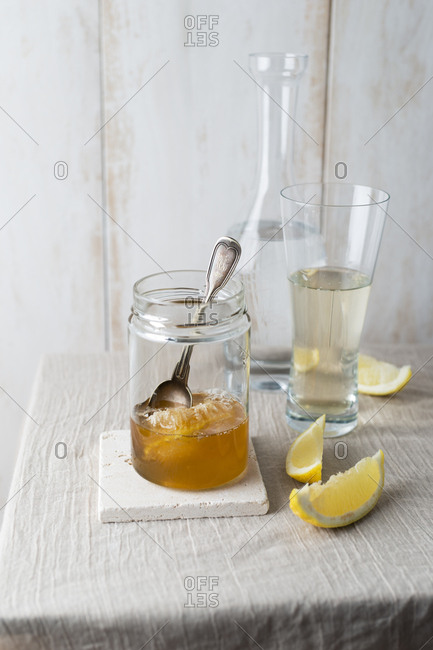 Honey jar with honeycomb and glass of water with honey