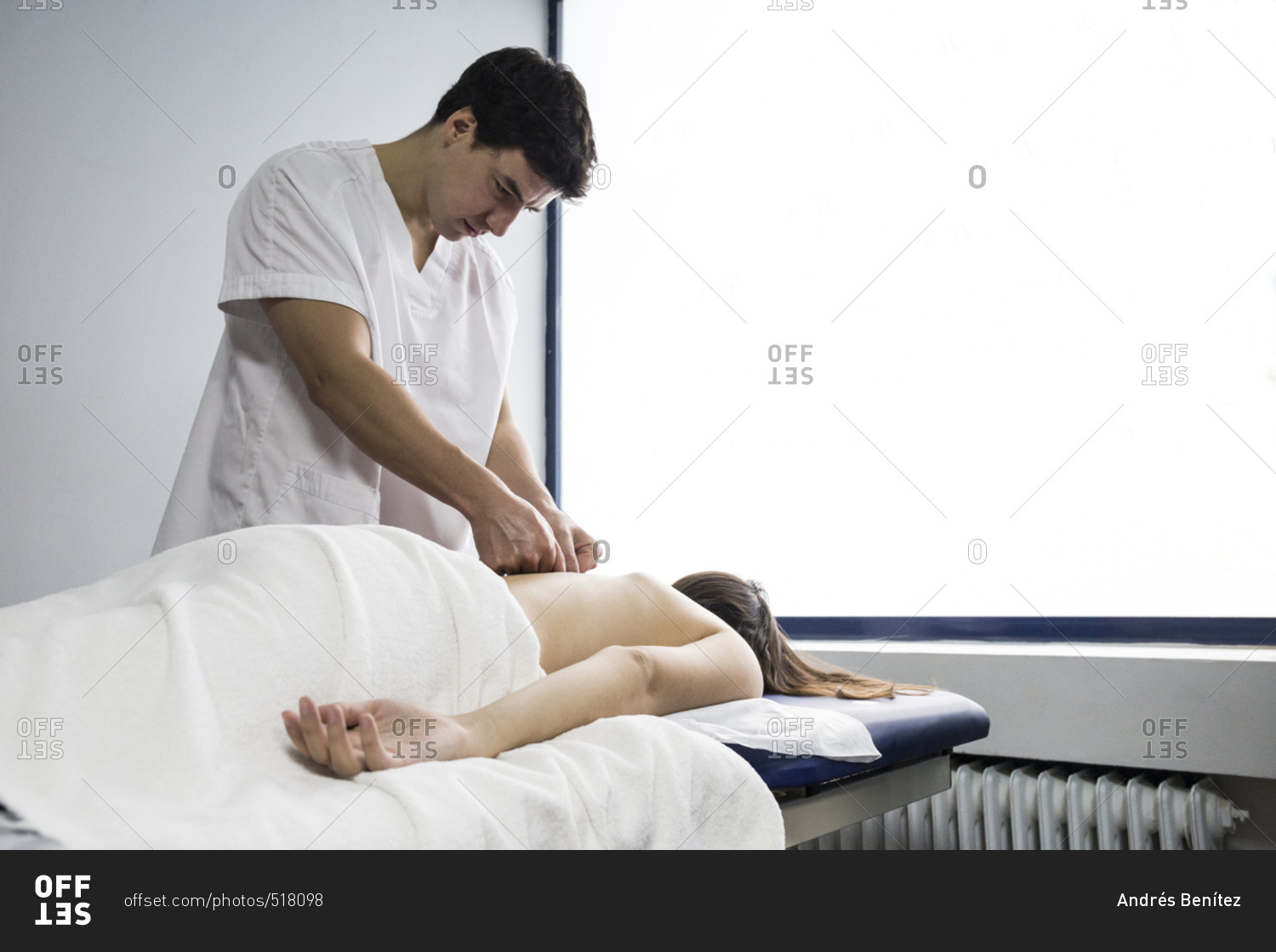 Physiotherapist kneading a client\'s back on a table