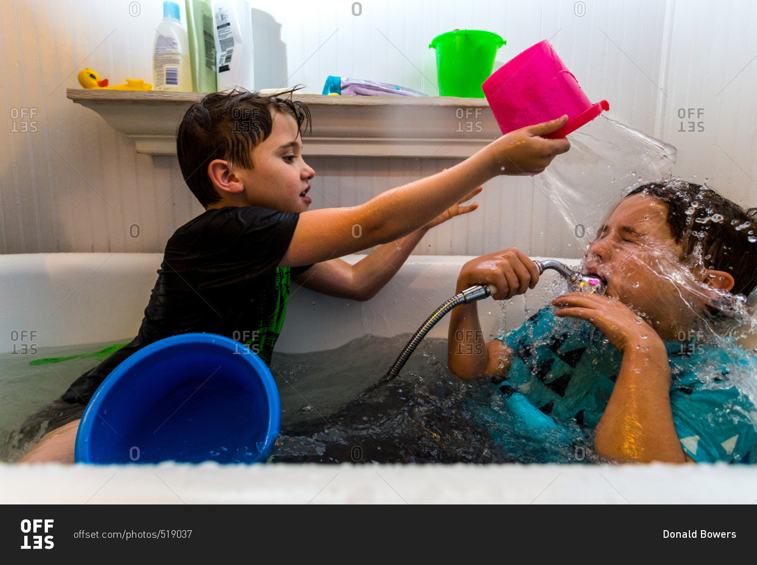 Twin Caucasian Brothers Play In Their Water Filled Bathtub Together With Their Clothes On Stock