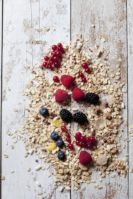 Granola with various wild berries on wood