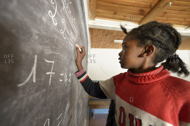 Madagascar- Girl in Fianarantsoa elementary school calculating at blackboard