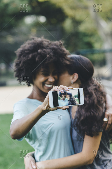 Two women taking selfie with smartphone in a park