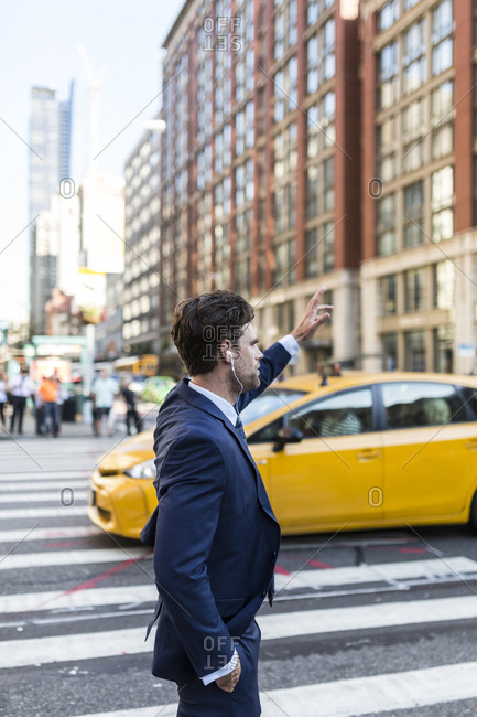 Businessman in the streets of Manhattan hailing a cab