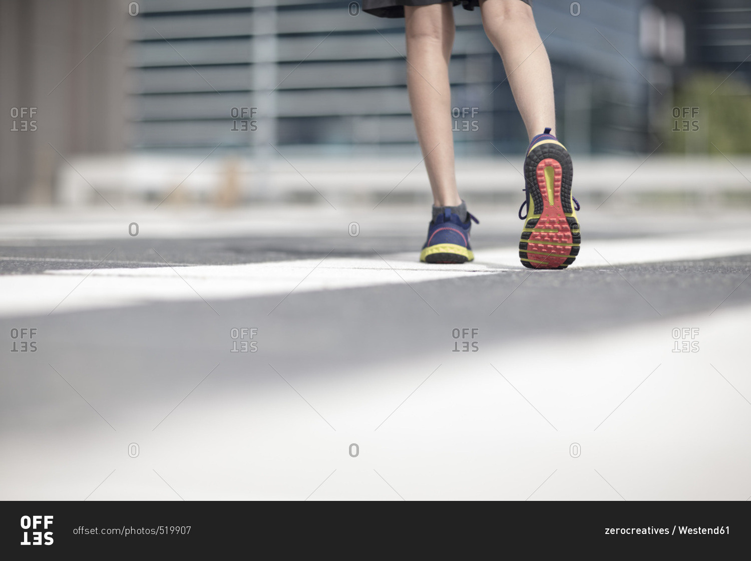 Legs of boy in sports shoes walking in the city