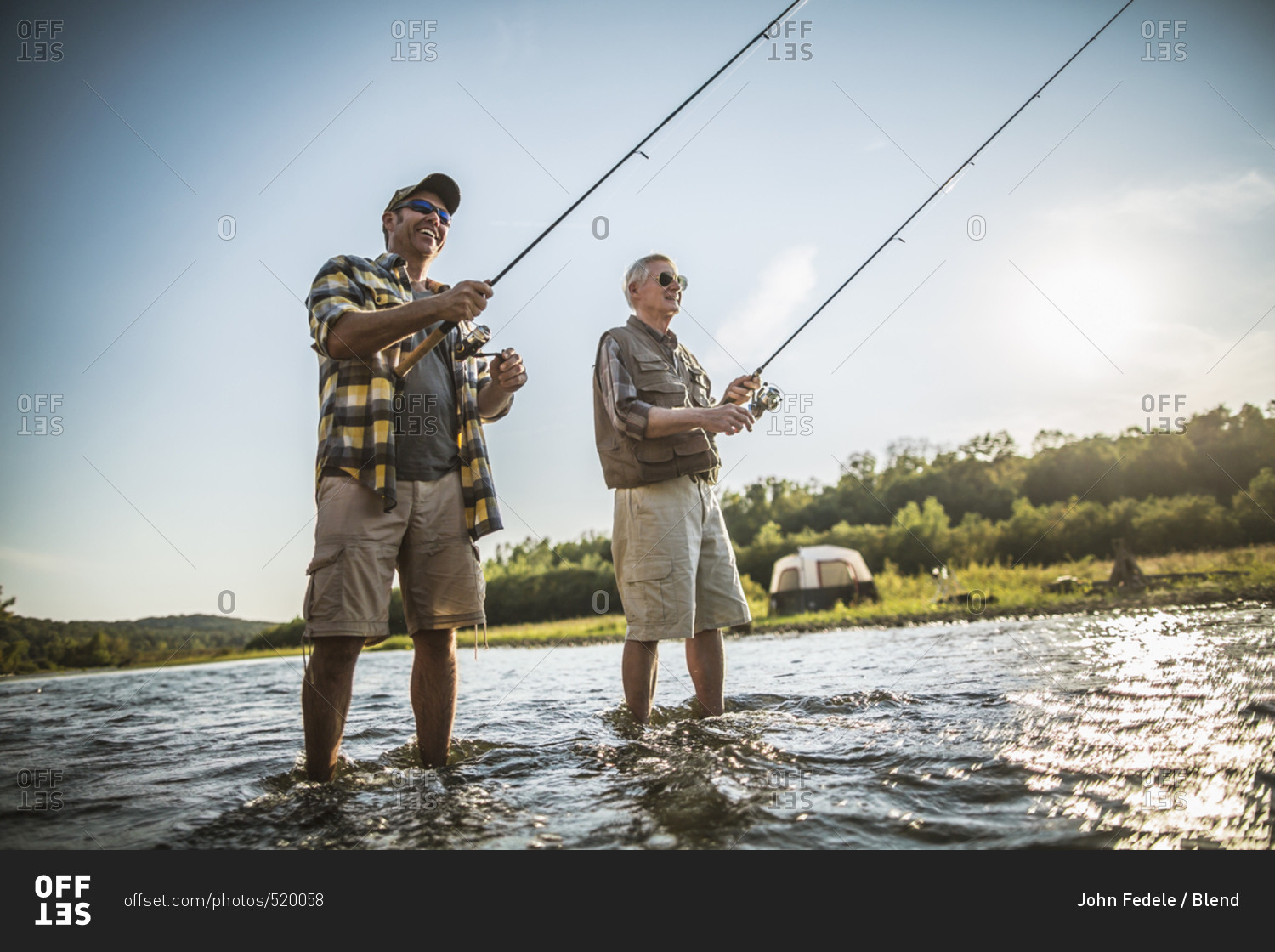 Caucasian father and son fishing in river