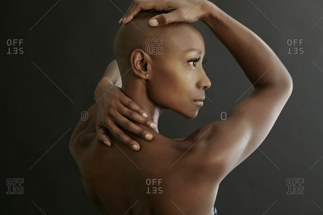 African American woman holding her bald head