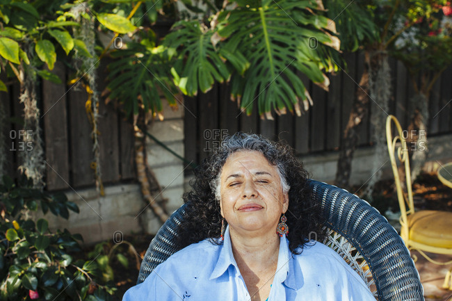 Hispanic woman relaxing in backyard