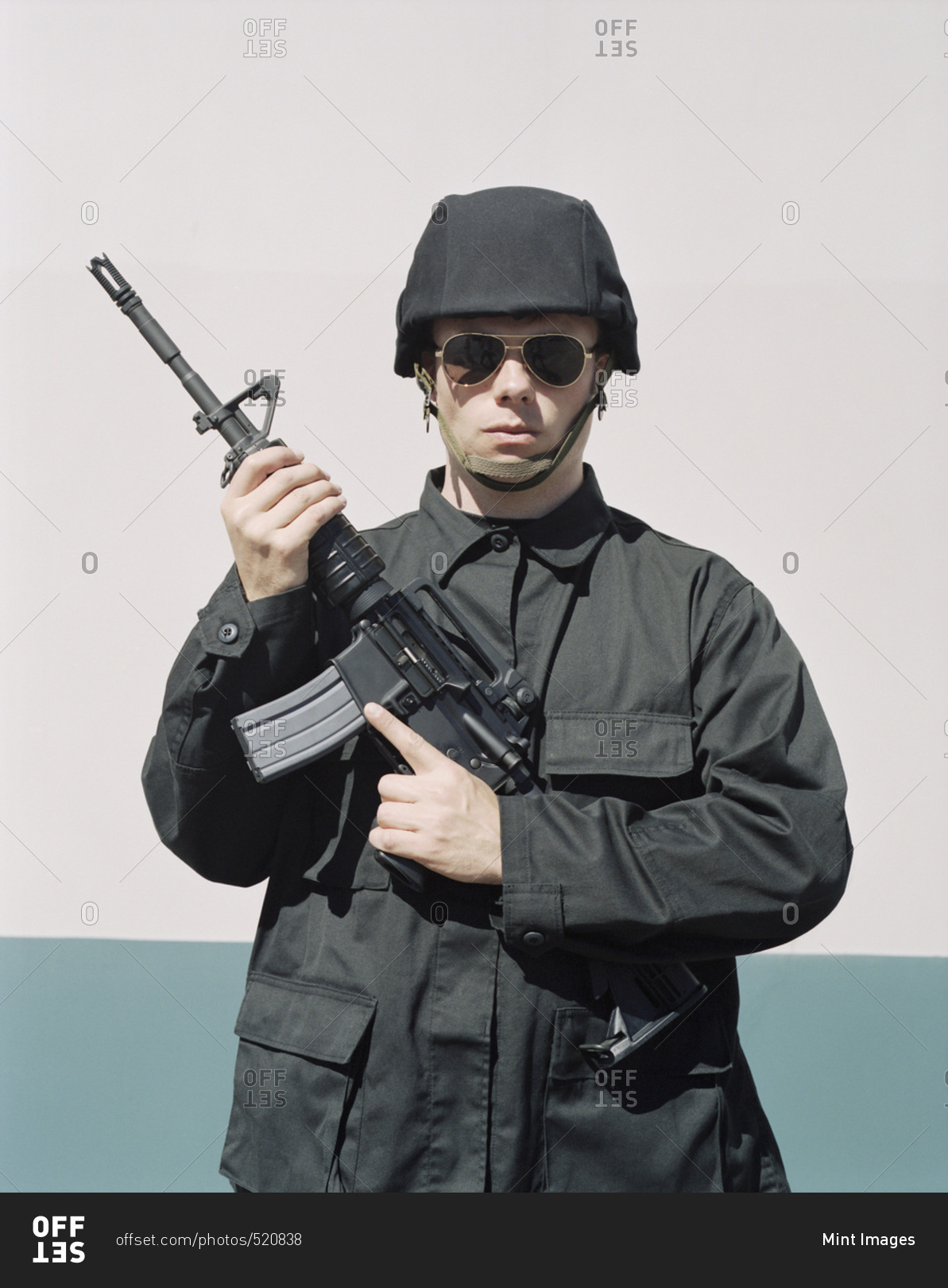 Man wearing special forces uniform and holding high powered semi-automatic rifle