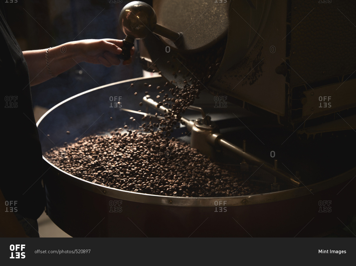 A coffee shop. A metal drum with roasting coffee beans and a central paddle.