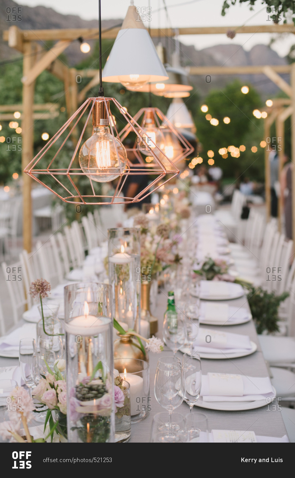 Light fixtures glowing over wedding table stock photo - OFFSET