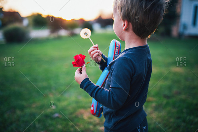 Boy with dandelion in sunrise