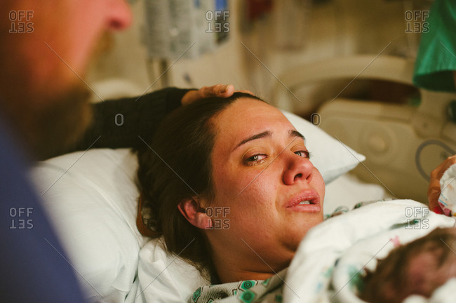 Woman lying in a hospital bed after giving birth stock photo - OFFSET