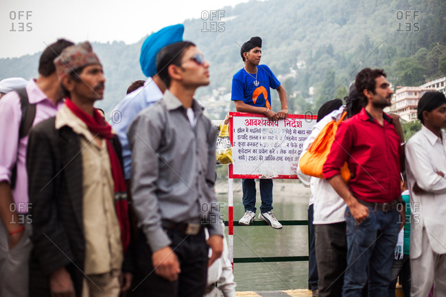 June 9, 2013 - Nainital, Uttarakhand, India: Sikh man standing on railing at lake among crowd of men