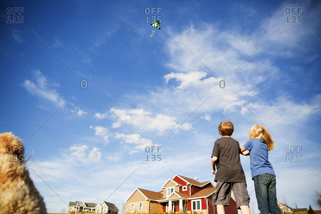 Low angle view of two children flying a kite
