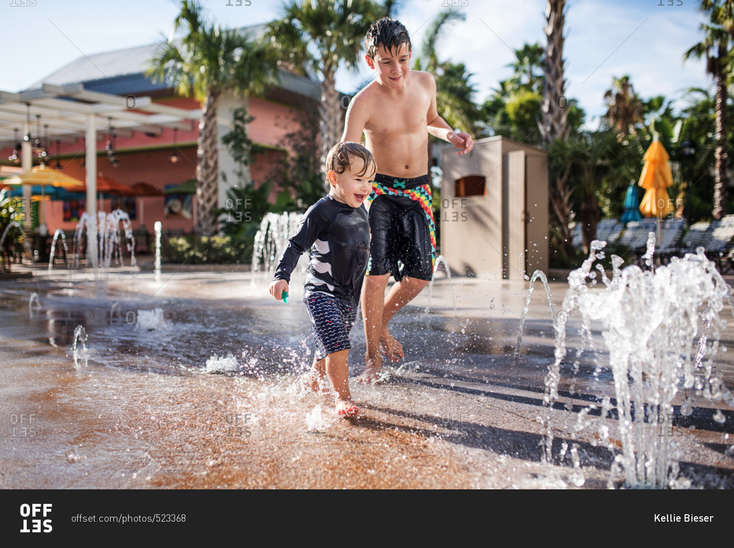 Two brothers playing in fountains at a splash park