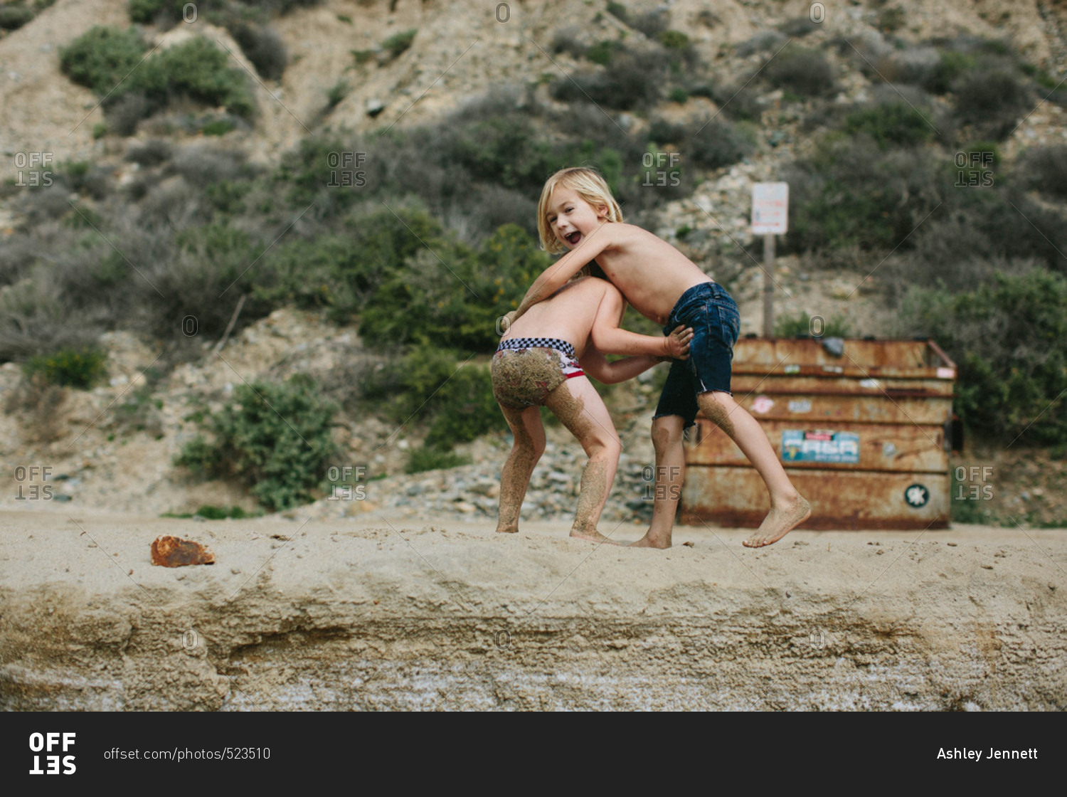 Two boys wrestling on a beach