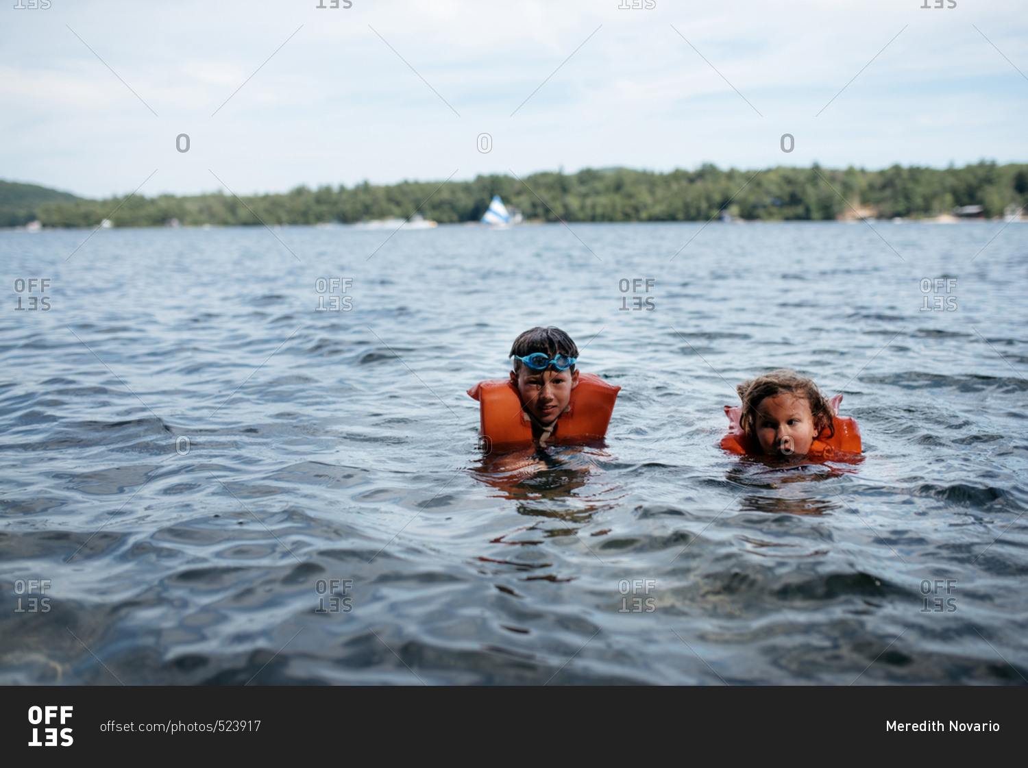 Two young children swimming in a lake stock photo OFFSET