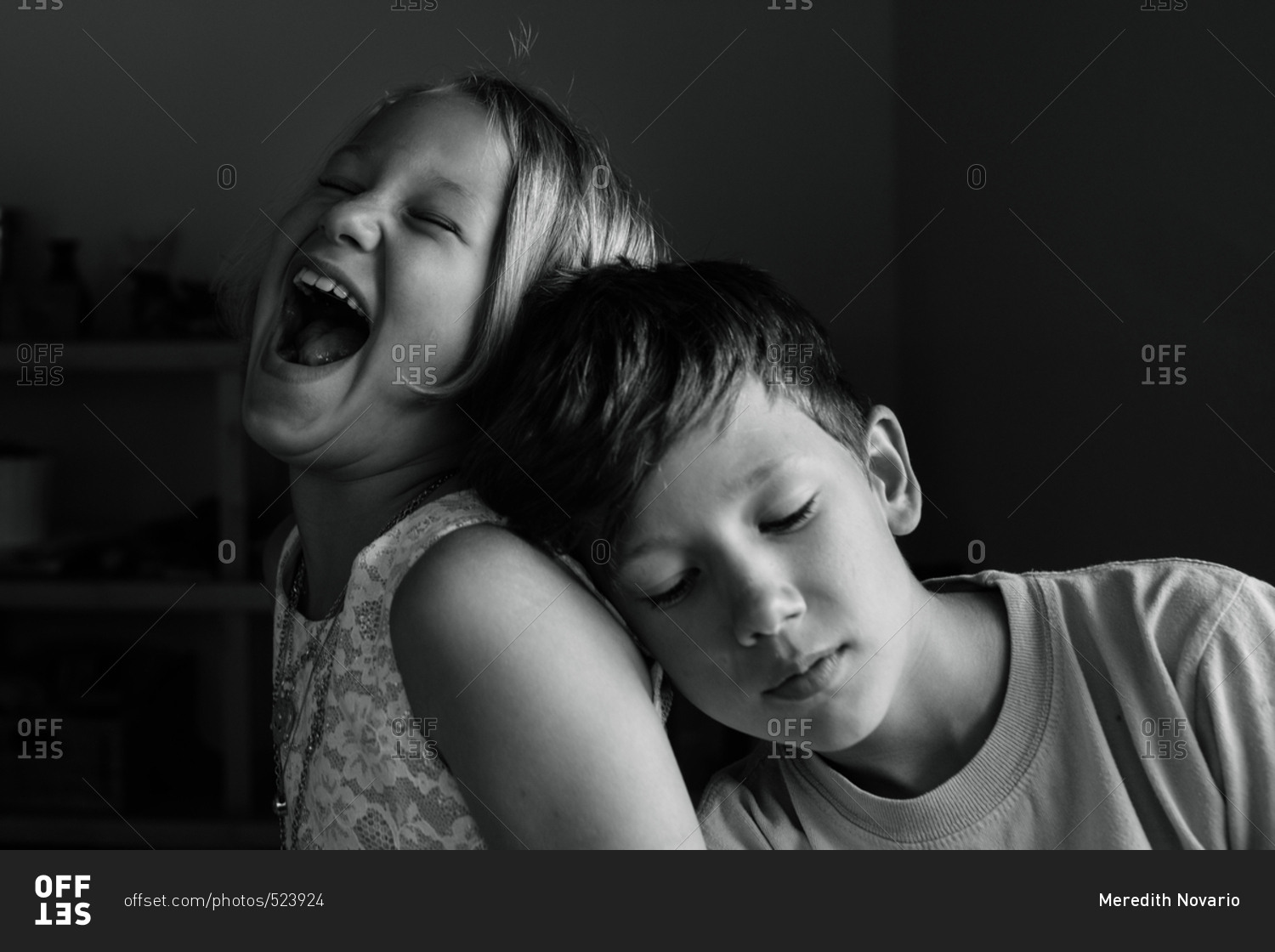 Portrait of two siblings, sister laughing and brother not amused