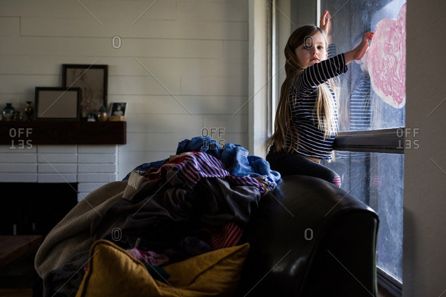 Girl on back of couch at window