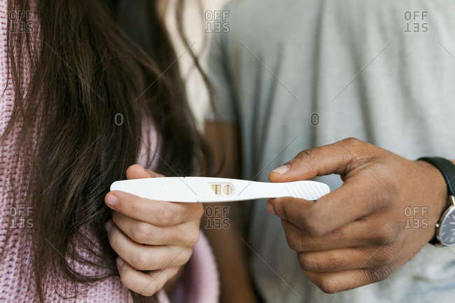 Young couple holding positive pregnancy test