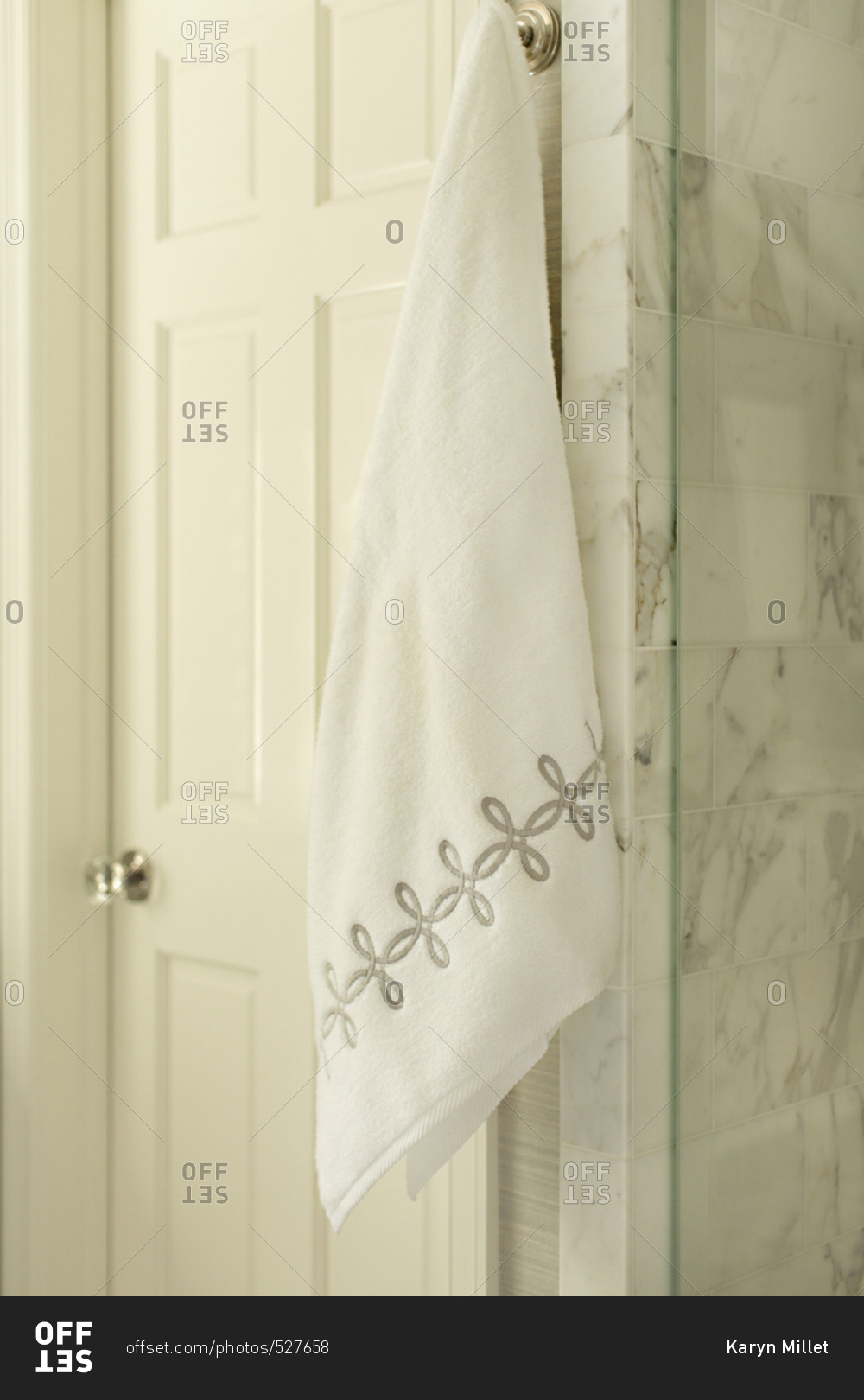 Embroidered towel hanging on hook in bathroom