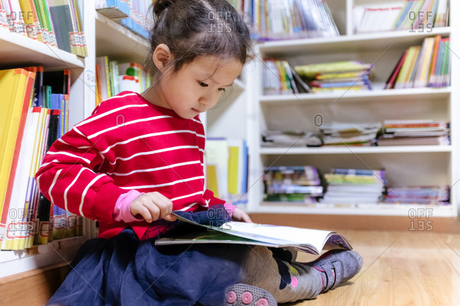 Girl reading on library floor
