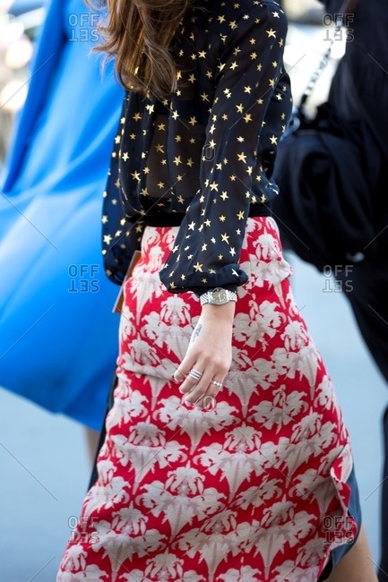 Woman in red patterned skirt and black blouse with stars